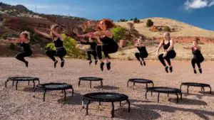 Eine Gruppe Frauen jumpt auf Trampolinen - jumping fitness