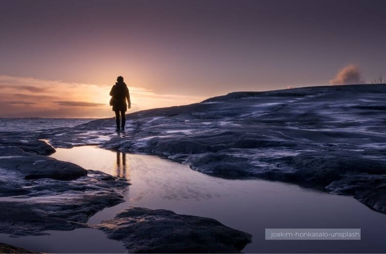 Eine Frau geht in Finnland an einem See spazieren