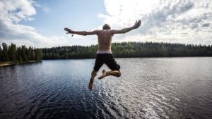 Ein Mann springt in Finnland in einen See