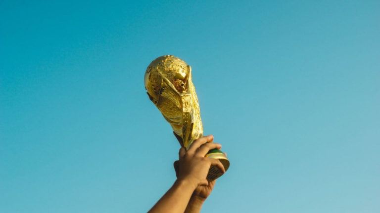 Motivierende Sprüche erfolgreicher Sportler Mit der richtigen Motivation zum Sieg jemand hält einen Pokal in die Luft